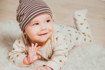 smiling baby lying on white mat