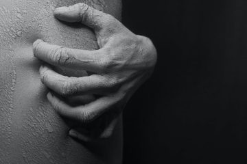 close up photo of a person s hand scratching on his flaky skin in black and white