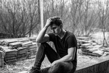 man sitting on concrete bench