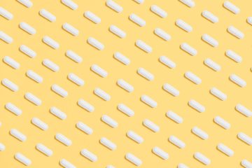 white capsules on yellow background