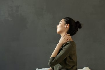 woman in gray dress sitting on bed