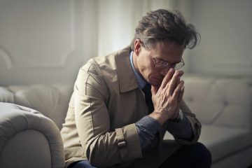 sad mature businessman thinking about problems in living room