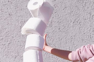 person in pink long sleeve jumper holding white tissue papers