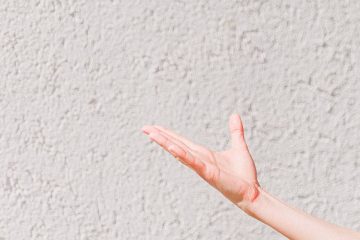 persons right hand near white wall