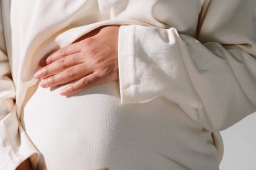 pregnant woman in white long sleeve dress