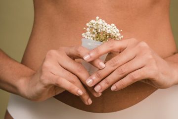 crop woman in underwear with plant in menstrual cup