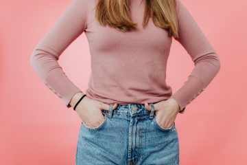 midsection of a woman against a pink background