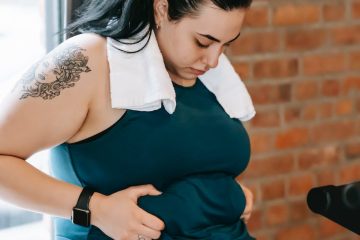 plus size woman holding fat fold on belly