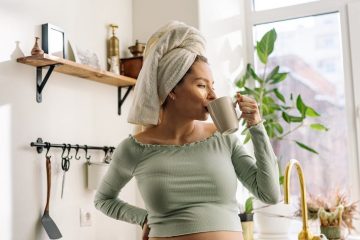a pregnant woman having a cup of hot drink