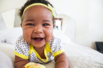 baby wearing white and yellow shirt