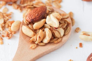almond nuts and flaxseed on wooden spoon