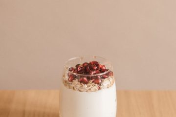 a glass of honey with pomegranate seeds and cereal